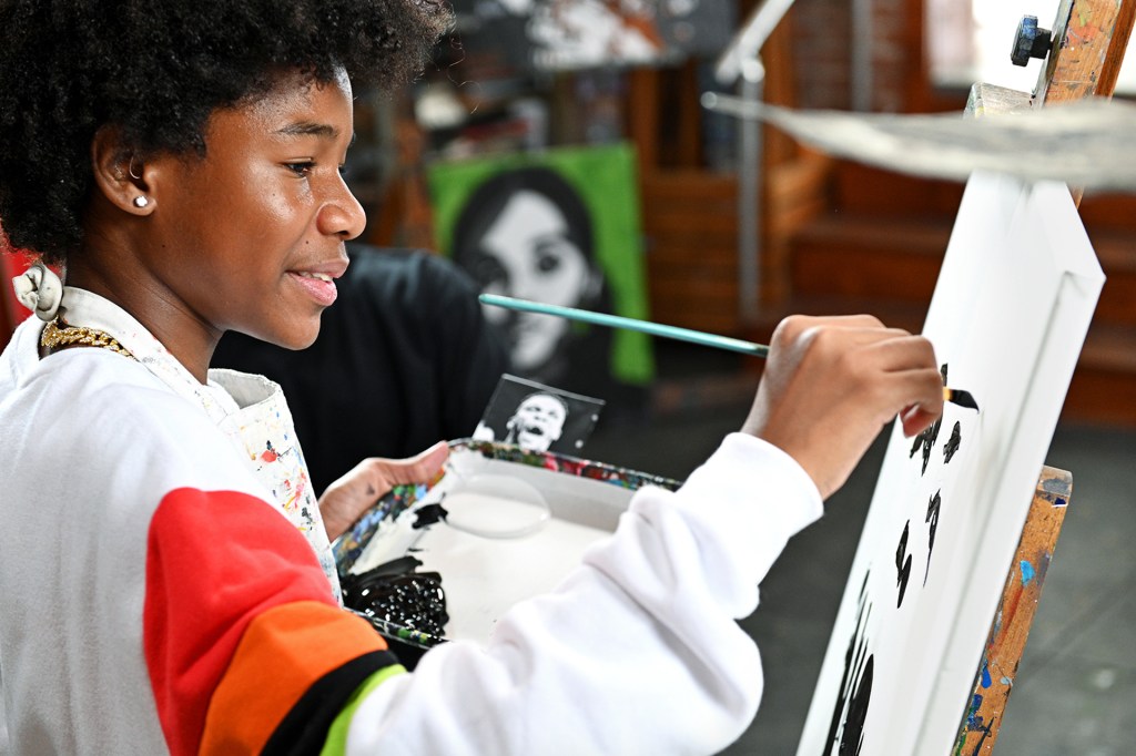 side profile of boy holding a paint brush