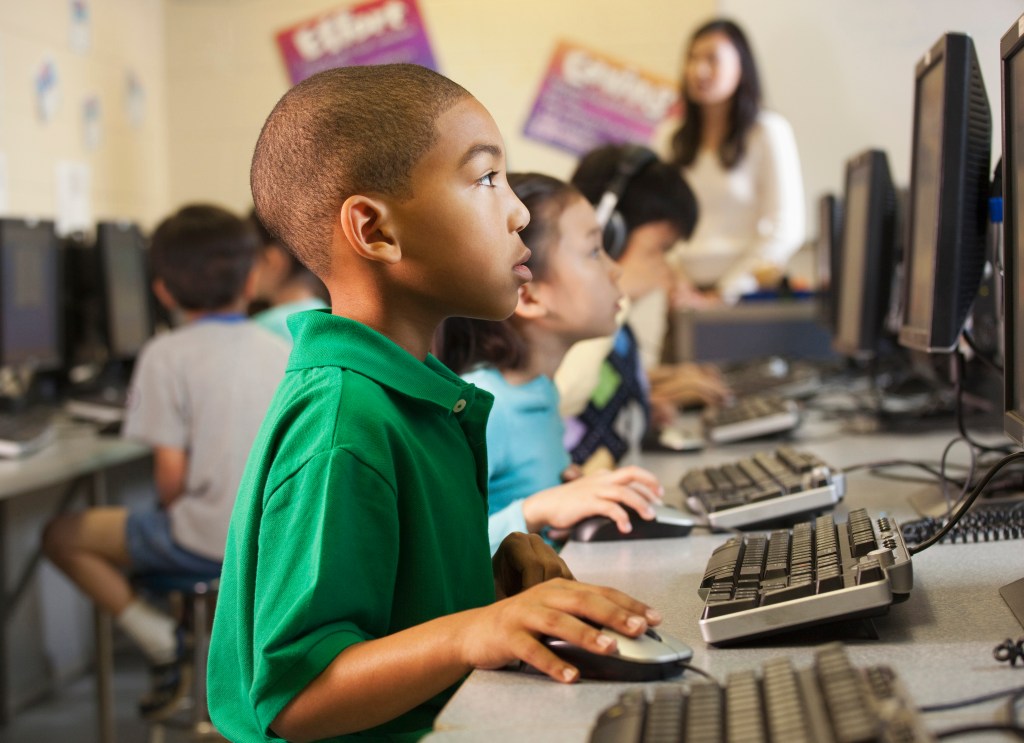 African American boy using computer in classroom