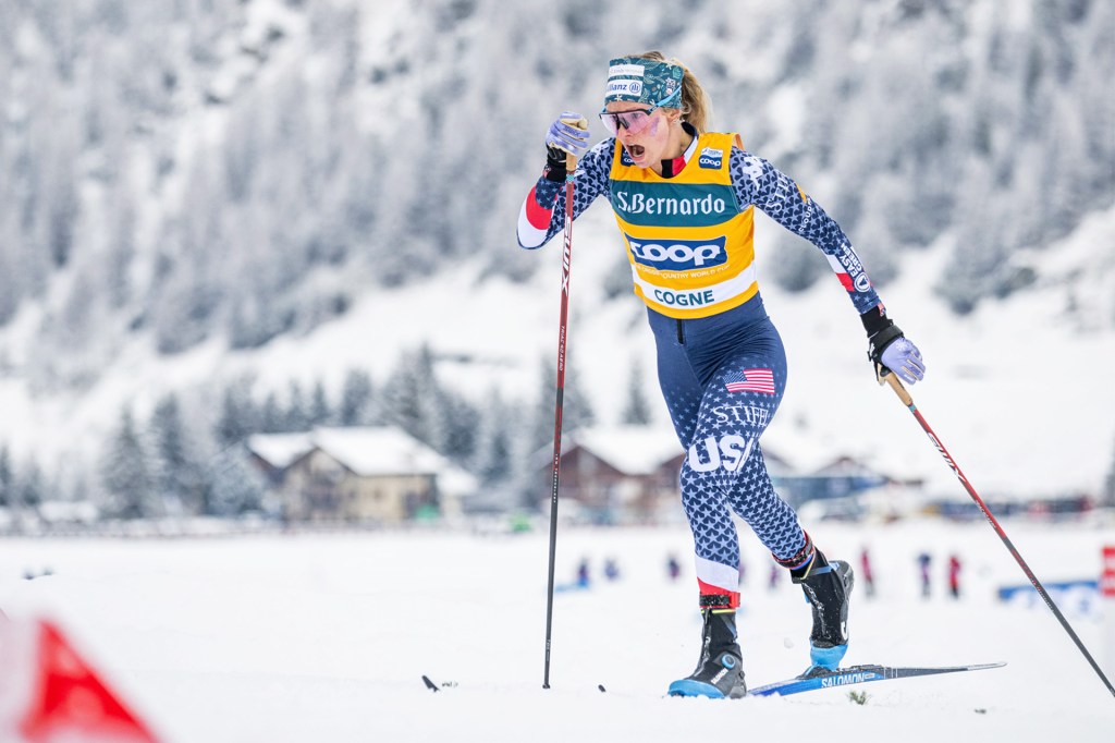 Cross‑country skier in USA suit races hard on a snowy course.