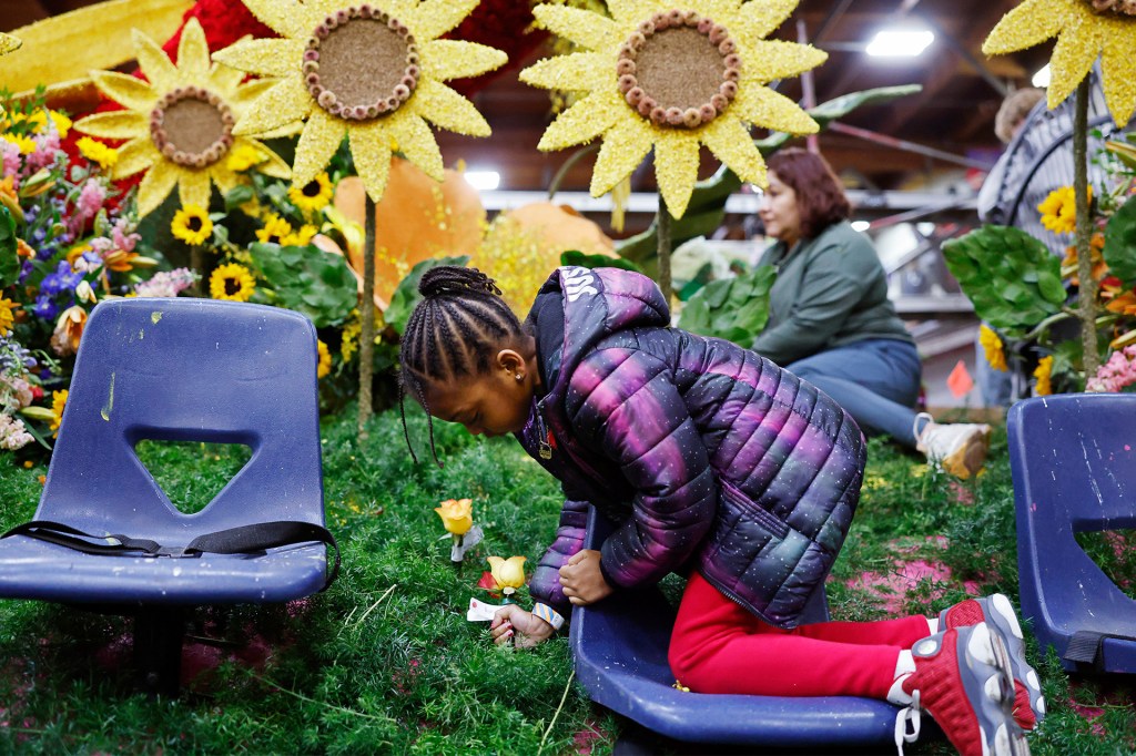 A girl adds flowers to a colorful scene decorated with big sunflowers.