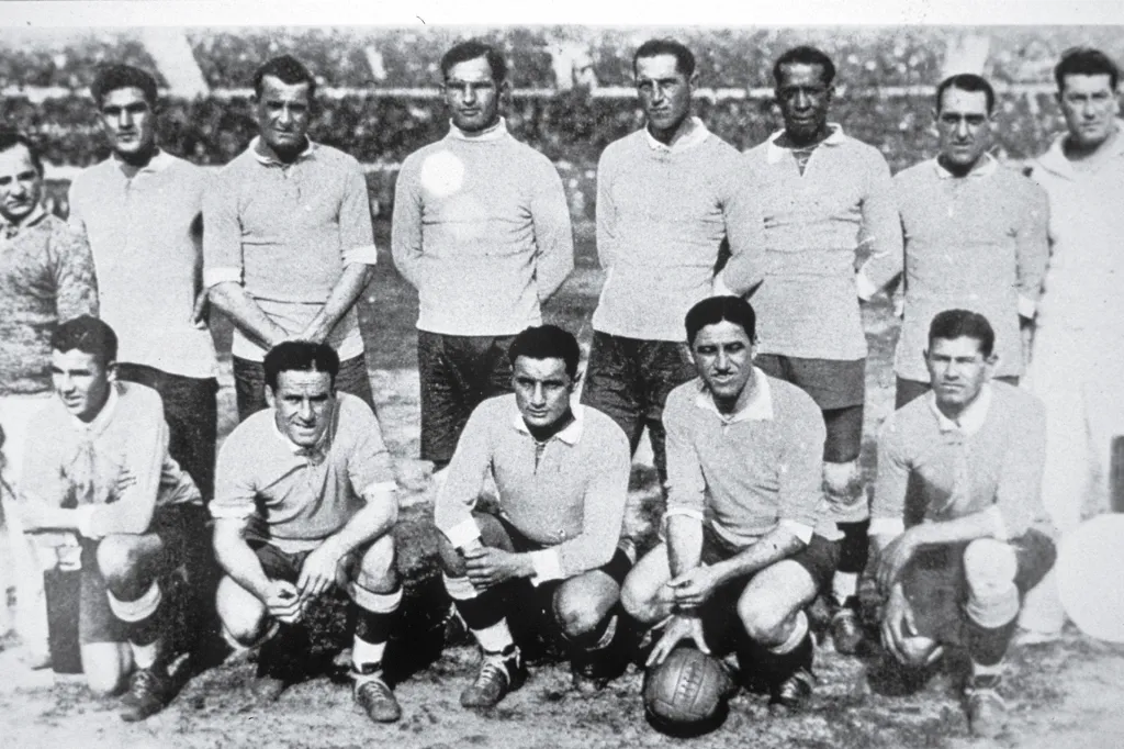 Black-and-white photo of a soccer team posing together on a field.