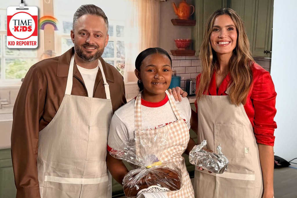 A child stands between two smiling adults in a kitchen, all wearing aprons and holding baked goods. A TIME for Kids Kid Reporter logo appears in the top left corner.
