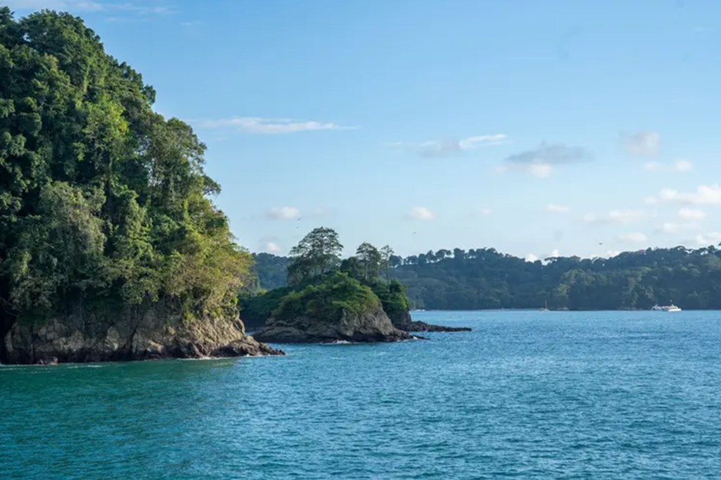 Rocky coastline, mangroves, and shallow bays stretch across a rugged landscape from above.