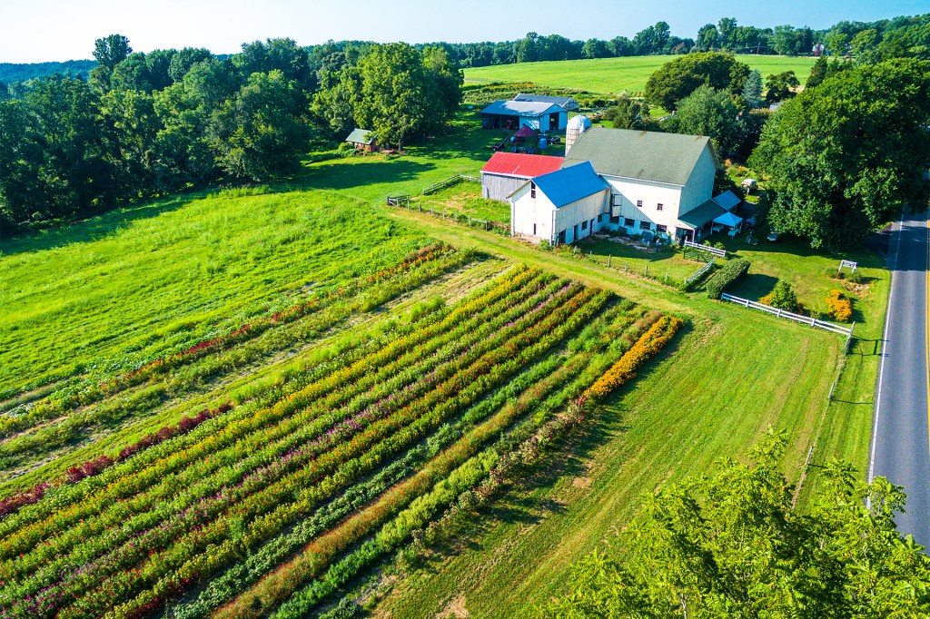 A farm with barns, fields, and rows of crops stretches across the countryside.