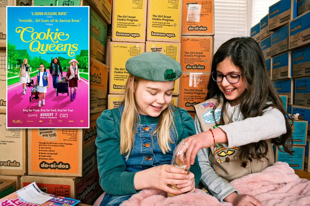 Two Girl Scouts sit in front of stacks of cookie boxes. A movie poster showing four Girl Scouts appears beside them.