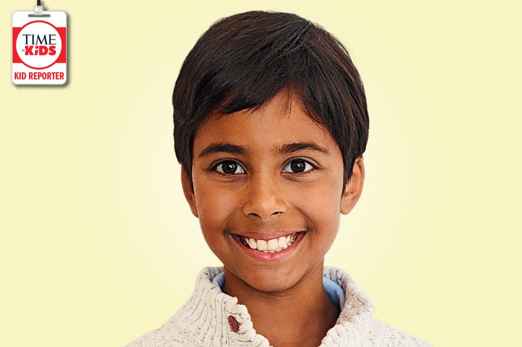 A smiling boy with short dark hair poses against a pale yellow background with a TIME for Kids Kid Reporter badge.