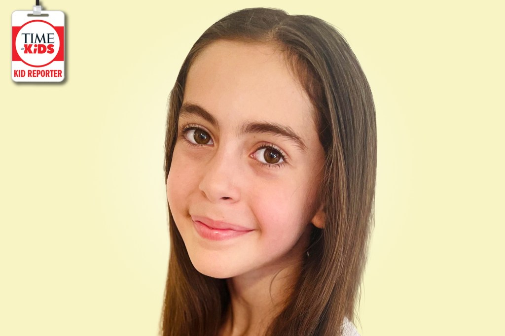 A smiling girl with long brown hair poses against a pale yellow background with a TIME for Kids Kid Reporter badge.