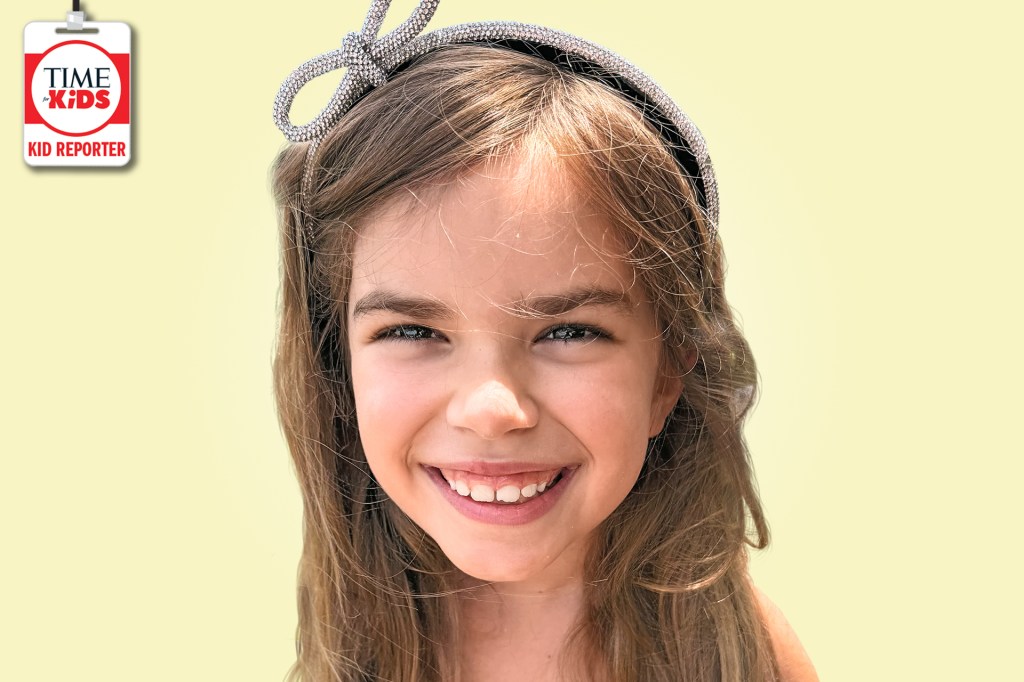 A smiling girl with long light-brown hair and a sparkly headband poses against a pale yellow background with a TIME for Kids Kid Reporter badge.