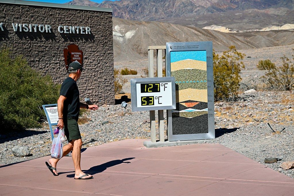 A temperature sign reads 127°F and 53°C outside a visitor center in a desert.