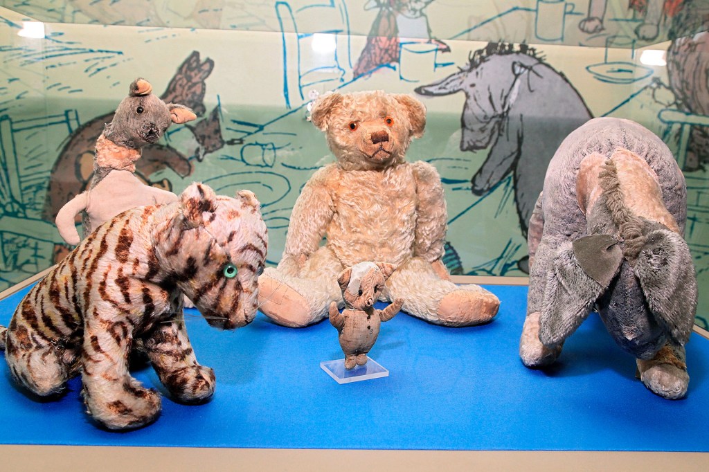 A display of stuffed animals including a teddy bear, tiger, pig, kangaroo, and donkey.